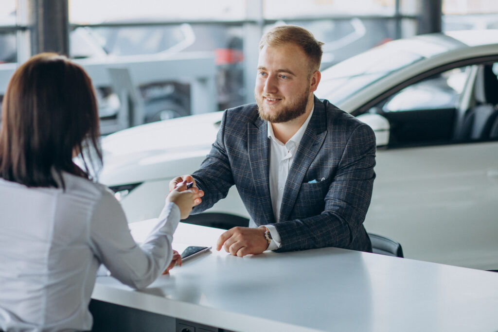 man with sales woman car showroom